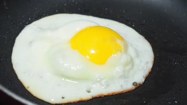 Close-up Eieren bakken in een kleine koekenpan. klaarmaken voor ontbijt — Stockvideo