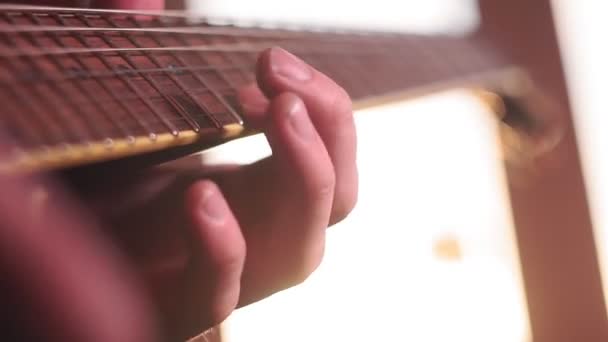 Ung man spelar på elgitarr på nära håll — Stockvideo