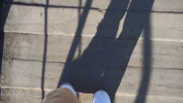 Homem de tênis branco caminha pela rua em um dia ensolarado brilhante. pov vídeo, primeira pessoa — Vídeo de Stock