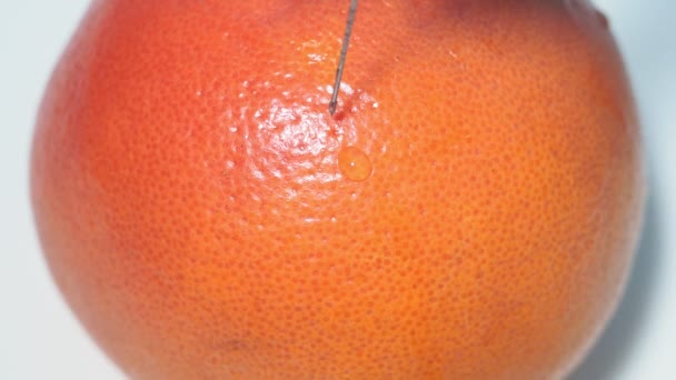 Injection d'OGM avec une seringue dans une orange, agrumes sinensis. Gros plan sélectif — Video