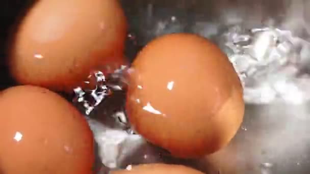 Huevos de pollo hirviendo en sartén de acero inoxidable, primer plano. agua hirviendo — Vídeos de Stock