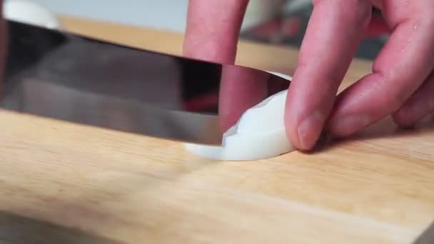 Homme coupant l'oeuf cuit sur la planche à découper avec le couteau. oeufs pour la salade, gros plan — Video