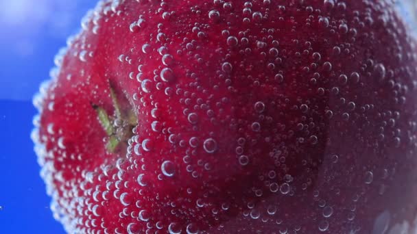 Moget saftigt rött äpple under vatten i selektivt fokus närbild makrovatten. frukt i vatten — Stockvideo