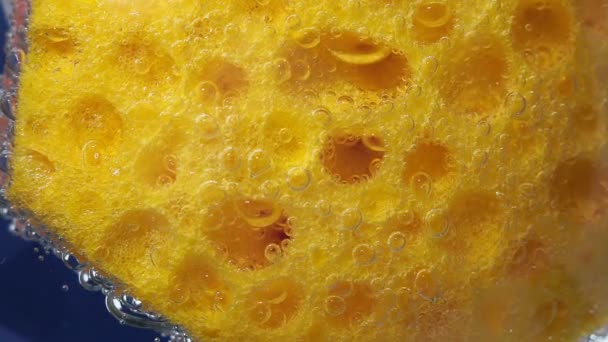 Текстура посудомийної губки фону. Поверхня жовтої губки для миття посуду. крупним планом під водою — стокове відео