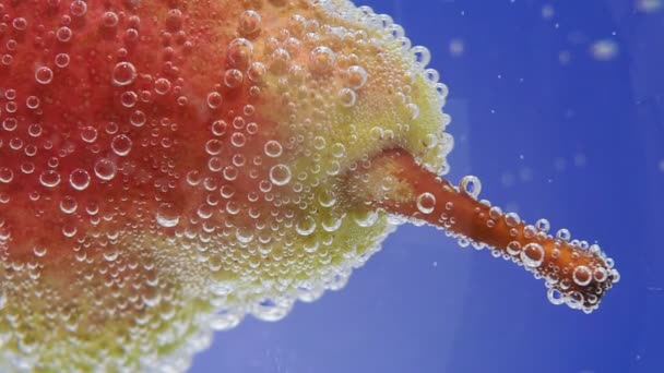 Birne im Wasser mit vielen kleinen Blasen. Selektive Fokussierung, Nahaufnahme. — Stockvideo