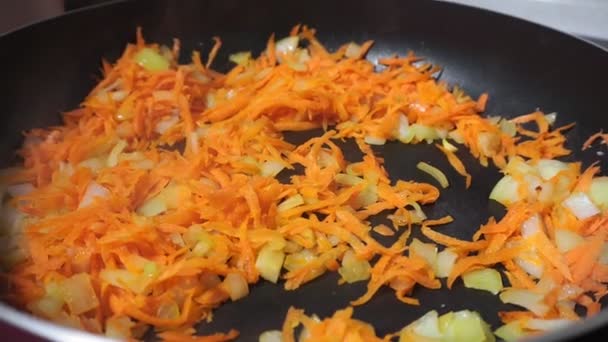 Faire frire les carottes sur la poêle à frire.Un gros plan de légumes dans une poêle à frire. Carotte orange gros plan — Video