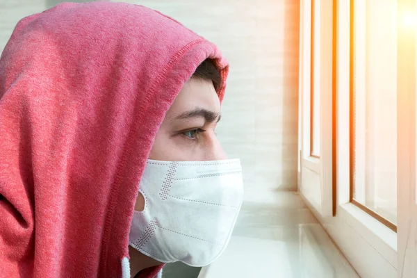 在家里戴着防护面具的男人 在自我隔离和隔离期间 他戴着外科医疗面罩站在窗前 以保护自己的面部不受考拉病毒感染 — 图库照片