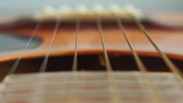 Çelik gitar tellerinin yakın çekim detayları ve müzik yapmak için perdeler. Seçici odak noktasında gitar boynu. — Stok video