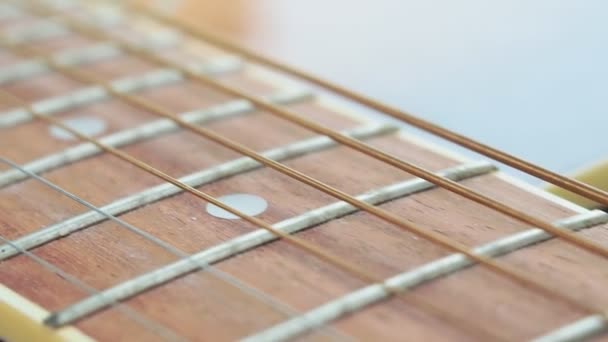 Chitarra acustica in legno marrone e parte del collo e delle corde messa a fuoco macro selettiva — Video Stock