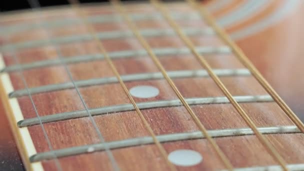 Guitar strings and frets for making music. Selective focus on one guitar threshold. — Stock Video