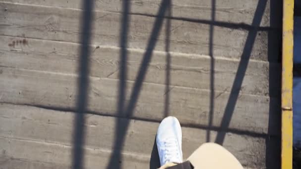 POV disparo de un hombre pies caminando en la acera con zapatillas blancas a plena luz del día — Vídeos de Stock
