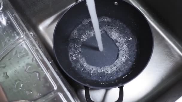 Fluindo água da torneira dentro da panela de cozinhar. conceito de fluxo de água. Salpicos de gotas de água — Vídeo de Stock