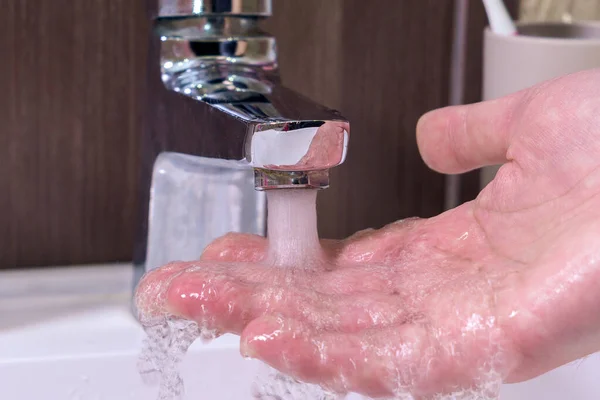 흐르는 손으로 만져서 온도를 확인하라 수돗물에서 손가락을 가까이 대거나 욕실에서 — 스톡 사진