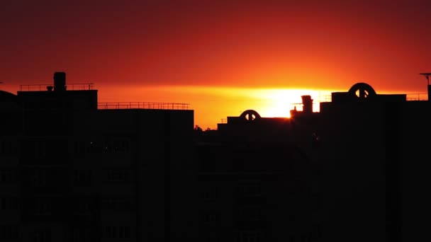 Turuncu günbatımında binaların silueti, renkli günbatımında binaların siluetleri, akşam şehirde, alacakaranlıkta yanan kızıl gökyüzü. — Stok video