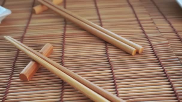 Tomma vita tallrikar, bambupinnar, rullsats, sushi — Stockvideo