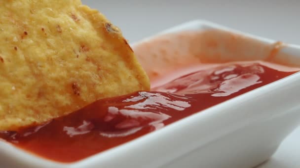 Zblízka namáčení tortilla chipsy v salsa omáčce. selektivní zaměření kukuřičné lupínky — Stock video