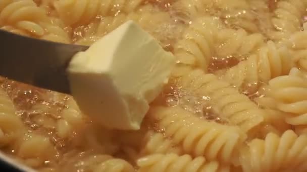 Smörolja till fusilli pasta. matlagning, kokta makaroner — Stockvideo