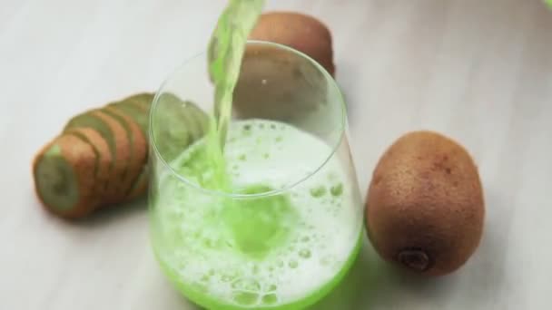 Glas grön lemonad med kiwi selektivt fokus. Han häller det i en glasbägare. — Stockvideo