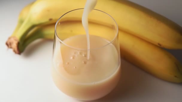 Ο χυμός μπανάνα χύνεται σε ένα ποτήρι. Μπανάνες, επιλεκτική εστίαση — Αρχείο Βίντεο