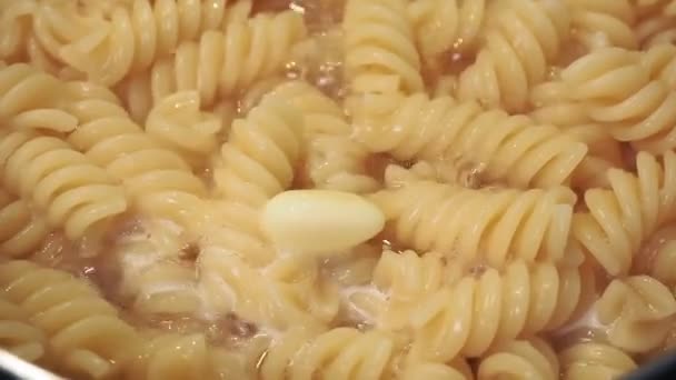 Boterolie tot fusilli pasta. voedselbereiding — Stockvideo
