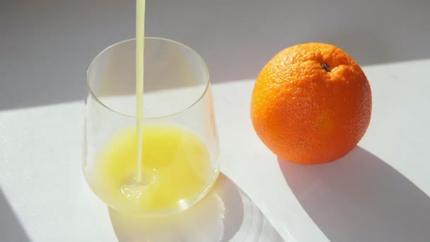 Chorro de jugo de naranja exprimido verter, primer plano disparar con enfoque selectivo . — Vídeo de stock
