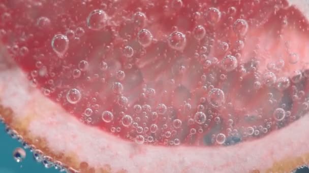Νερό πιτσιλιές γκρέιπφρουτ με φυσαλίδες. ζουμερά ώριμα φρούτα σε νερό close-up, μακροεντολή — Αρχείο Βίντεο