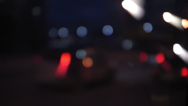 Desconcentração do tráfego rodoviário à noite. Luzes turvas de luzes de cabeça da cidade e do carro — Vídeo de Stock