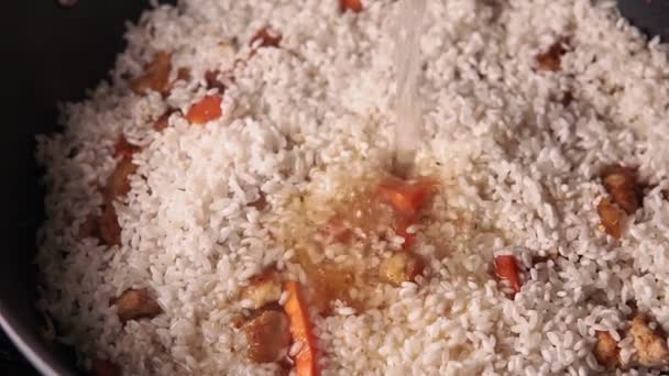 Gotowanie pilaf zbliżenie. Ryż gotowany, wieprzowina czosnkowa i marchewka w plasterkach. — Wideo stockowe