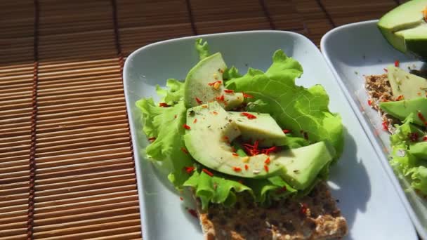 Knäckebröd met salade en avocado bovenaanzicht. Gezond en gezond ontbijt — Stockvideo