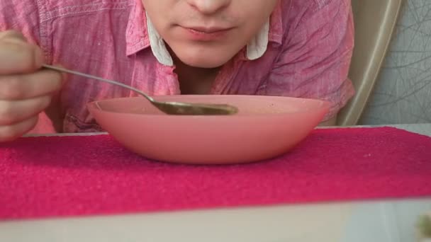 Young man eating pea soup close up — Stock Video