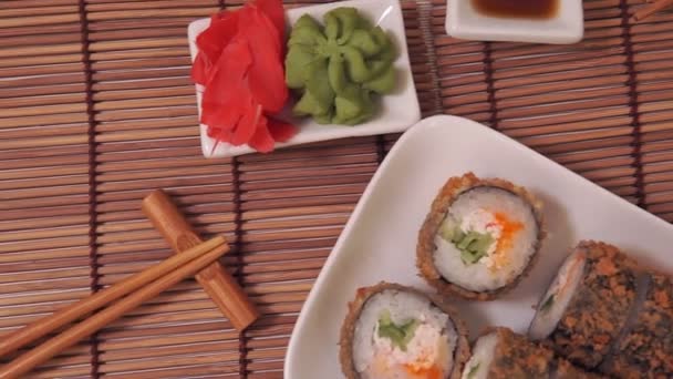 Broodje Japans eten, gerecht bestaande uit rijst, zalm, tonijn, sesam, soja, vis. — Stockvideo