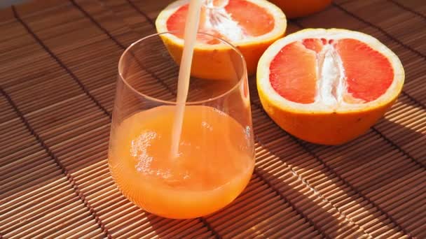 Glas rijpe grapefruit met sap op tafel close-up — Stockvideo