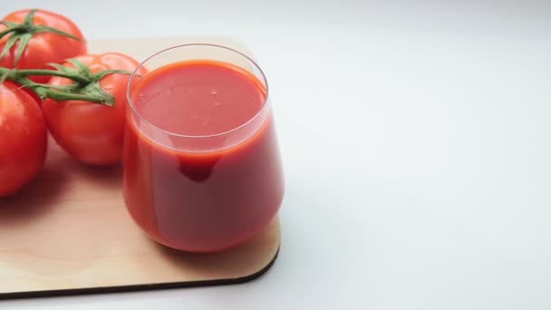 熟した赤いトマトとガラスのトマトジュース。選択的フォーカスを閉じる — ストック動画