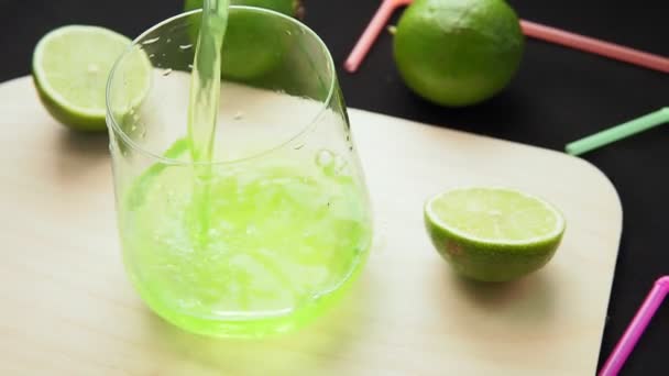 Χύνει ποτήρια λεμονάδα με lime, ξύλινο Διοικητικό Συμβούλιο. επιλεκτική εστίαση — Αρχείο Βίντεο