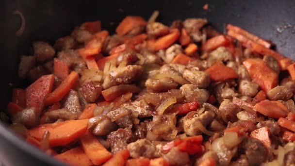 Geroosterd varkensvlees met wortelen in een pan, het proces van het koken van pilaf — Stockvideo