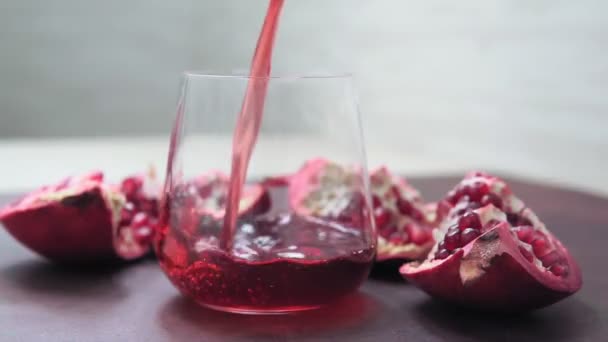 Röd genomskinlig saft som hälls i glaset med stänk och bubblor. — Stockvideo