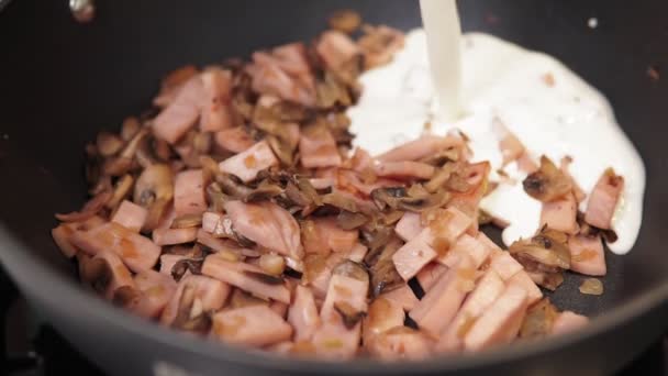 Cocinar la pasta Carbonara añadiendo salsa de crema. Concepto de cocina italiana . — Vídeos de Stock