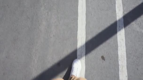 Hombre en zapatillas blancas camina por la calle en un día soleado brillante . — Vídeos de Stock
