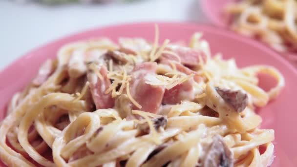 Acrescentando queijo ao macarrão, espaguete Carbonara em molho de creme com presunto — Vídeo de Stock