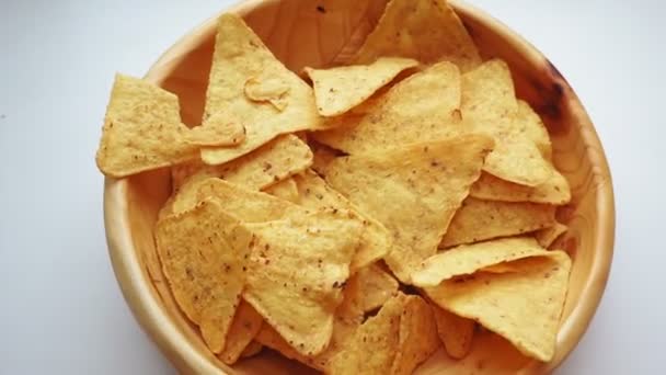 Ruka vezme žluté kukuřice nacho chipsy z talíře zblízka — Stock video