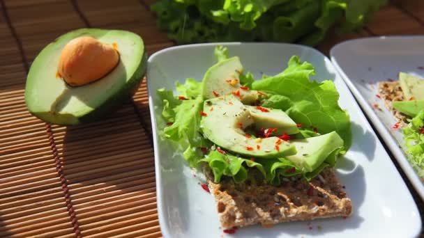 Bruschetta, awokado i świeżo zmielony pieprz. Zdrowa dieta Śniadanie — Wideo stockowe