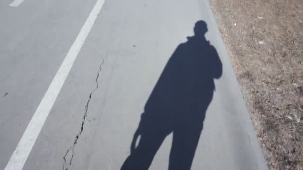 Ombre d'un homme sur le trottoir par un jour ensoleillé — Video