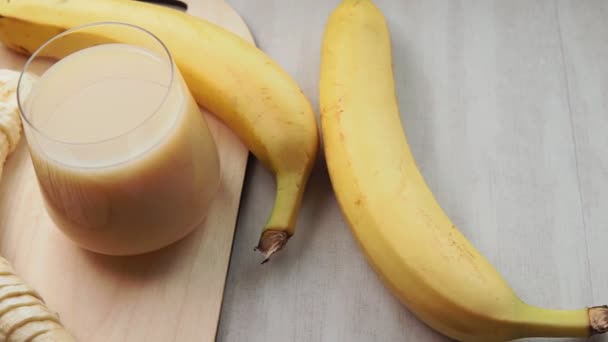 Banansmoothie. Bananer på en grå bakgrund ljus, selektivt fokus — Stockvideo