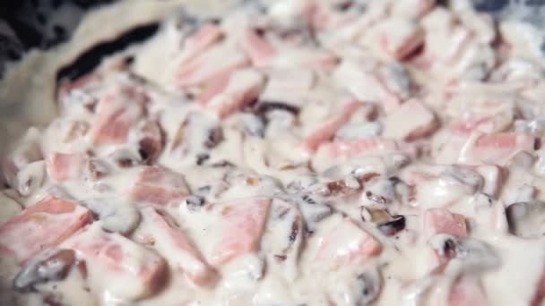 Cozinhar Carbonara com cogumelos e presunto, queijo e molho de creme . — Vídeo de Stock