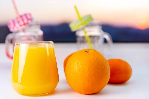 Glass of orange juice and oranges fruit, selective focus. at sunset, place for text, copy space — Stock Photo, Image