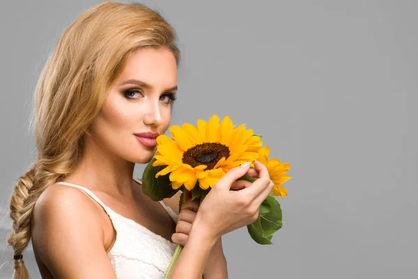 Porträt der attraktiven Sommerfrau mit Sonnenblume in der Hand auf bl — Stockfoto