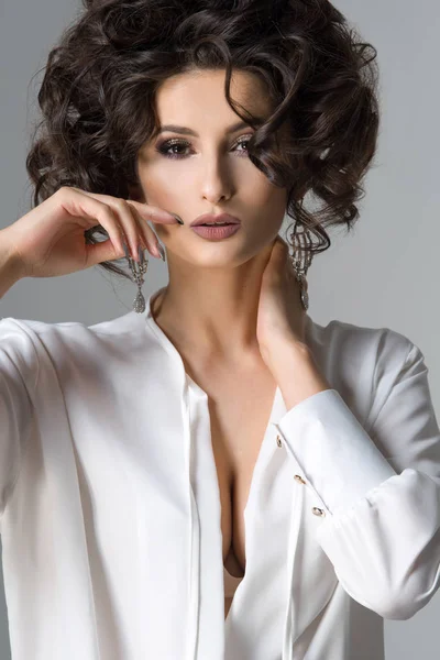 Sensuale bella donna bruna posa in camicia bianca e orecchini. Ragazza con lunghi capelli ricci . — Foto Stock