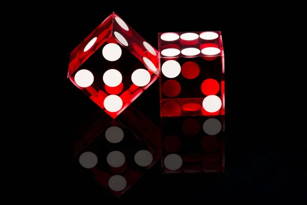 Red dices on a black background — Stock Photo, Image