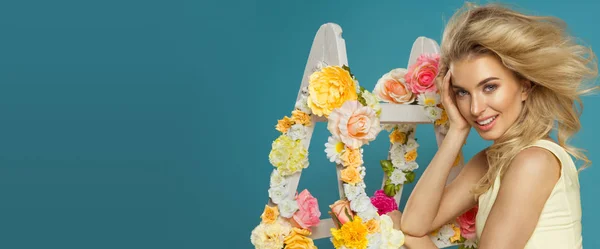 Jemná blondýnka s květinovými bílý žebřík — Stock fotografie