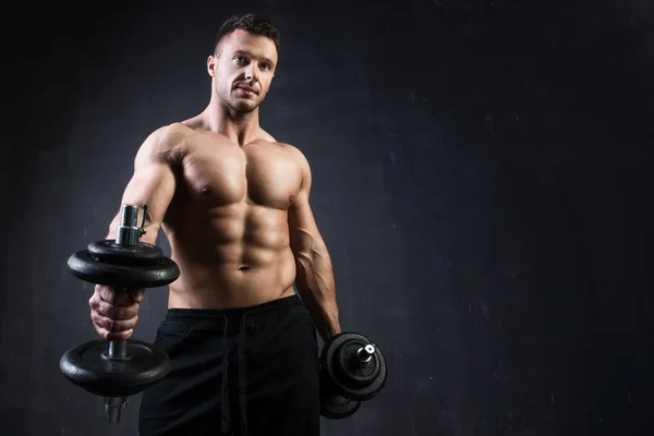 Schöner muskulöser Bodybuilder, der seine Muskeln zeigt. — Stockfoto